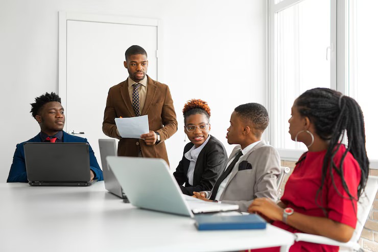 Young professionals collaborating around laptops in a meeting